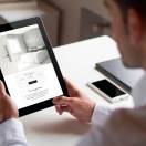 bussinessman at office holding a tablet showing booking hotel website. All screen graphics are made up.