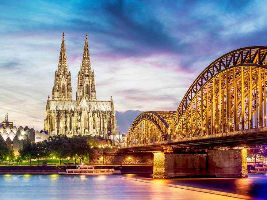 Illuminated Dom in Cologne with bridge and rhine at sunset